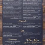 A restaurant menu from Pla-Mor Bar and Restaurant at Lake Namakagon. The menu is divided into sections: Dinner, Specials, Kids, and Beverages. The Dinner section includes items such as Chicken Bruschetta ($22.00), Chef's Specialty Short Rib ($30.00), BBQ Ribs (full rack $38.00, half rack $20.00), Butternut Squash Ravioli ($20.00), Chicken Parmesan ($25.00), Chicken Gnocchi ($26.00), Chortlewood's Comfort ($21.00), Cedar Plank Salmon ($28.00), Cavatappi Primavera ($20.00, add grilled chicken $4.00, add grilled shrimp $6.00), and Grilled Ribeye ($35.00, upgrade to 16oz $3.00). The Specials section lists Saturday Ribeye ($30.00, upgrade to 16oz $3.00), Friday \"AYCE\" Pollock ($18.00, add side salad or cup of soup $3.00), Wednesday Wing Night ($16.00), and Friday Walleye Dinner ($26.00, add side salad or cup of soup $3.00). The Kids section includes Grilled Cheese ($10.00), Chicken Nuggets ($10.00), and Mini Corn Dogs ($10.00). The Beverages section lists various drinks including Coke, Diet Coke, Sprite Zero, Mellow Yellow, Mr. Pibb, Ginger Ale, Lemonade, Unsweetened Iced Tea, 1919 Root Beer, Shirley Temple, and Seasonal Juice, all priced at $3.50. The menu also mentions that dinner is served after 4 PM with house soup or salad, and gift cards are available.
